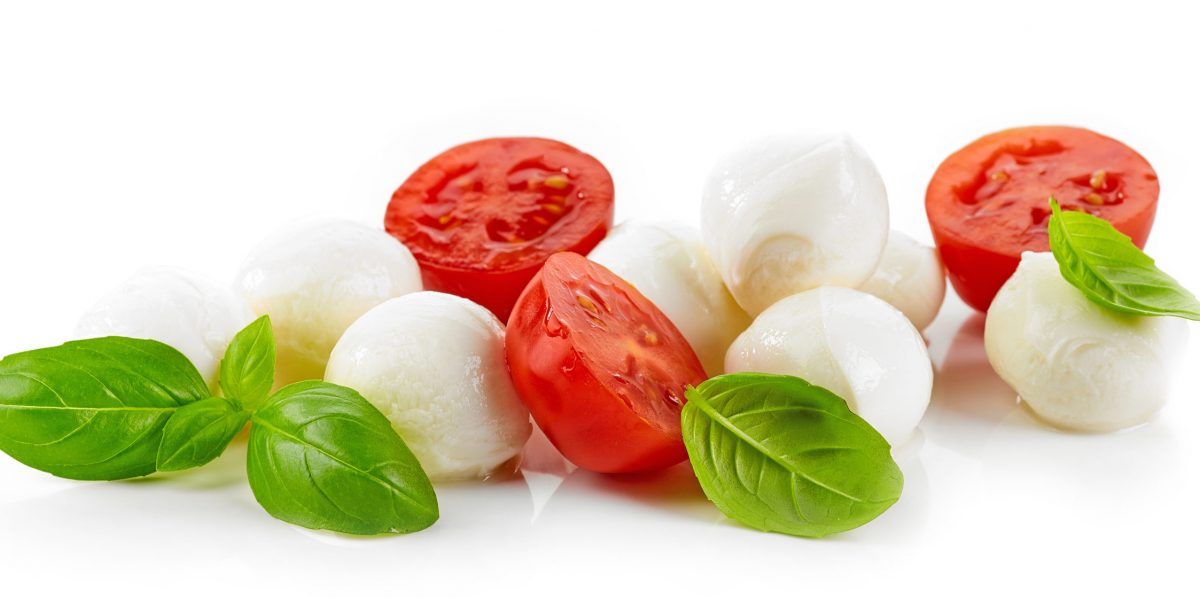 Mozzarella cheese balls with tomato and basil isolated on white background