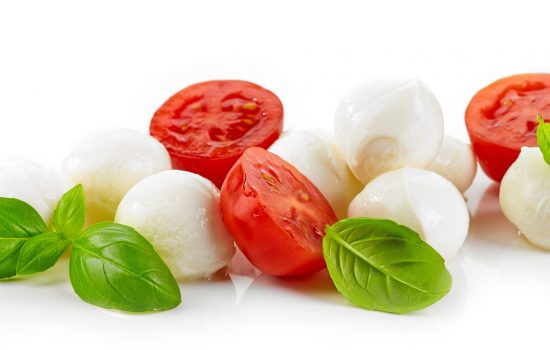 Mozzarella cheese balls with tomato and basil isolated on white background